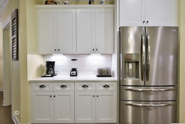 kitchen featuring white cabinetry, decorative backsplash, and stainless steel fridge with ice dispenser