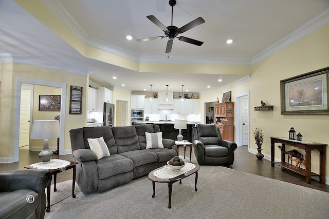 living room featuring wood-type flooring, ceiling fan, ornamental molding, and sink