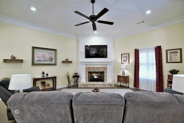 living room featuring wood-type flooring, a brick fireplace, ceiling fan, and ornamental molding