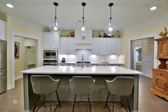 kitchen featuring white cabinets, a center island with sink, and appliances with stainless steel finishes