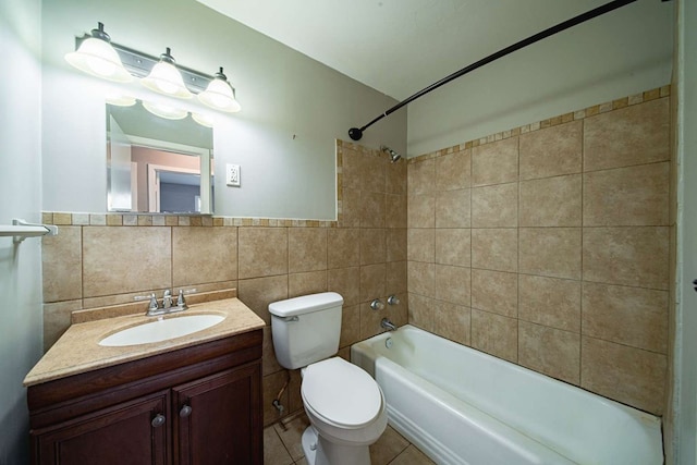 full bathroom featuring tile patterned floors, toilet, tile walls, bathing tub / shower combination, and vanity