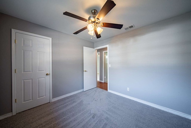 unfurnished bedroom featuring a ceiling fan, baseboards, visible vents, and carpet floors