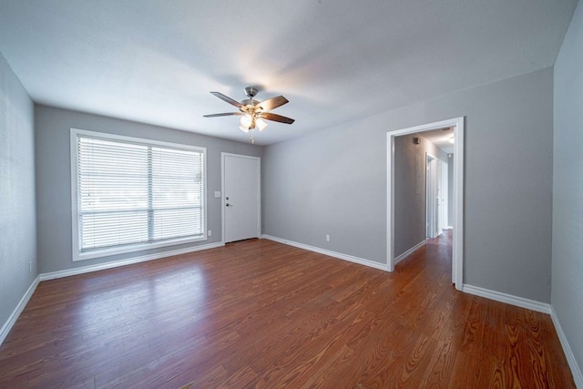 unfurnished room featuring wood finished floors, baseboards, and ceiling fan