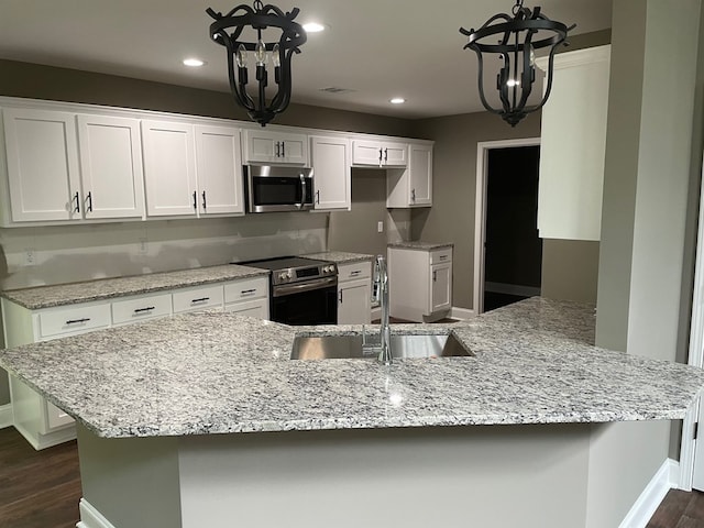 3077 Reese Rd, Columbus, GA 31907 - kitchen with appliances with stainless steel finishes, a chandelier, dark wood-style floors, white cabinets, and recessed lighting