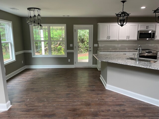 3077 Reese Rd, Columbus, GA 31907 - kitchen with appliances with stainless steel finishes, decorative light fixtures, white cabinetry, light stone countertops, and dark wood-style flooring
