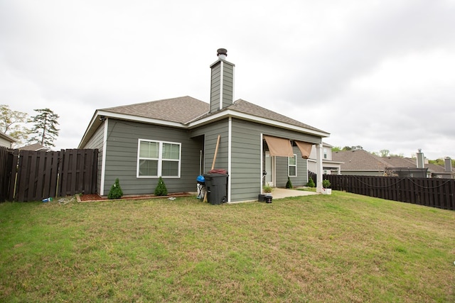 6845 Admiral Dr, Midland, GA 31820 - back of property featuring a yard, a fenced backyard, a patio area, and a chimney