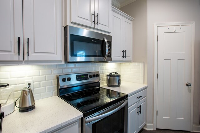 6845 Admiral Dr, Midland, GA 31820 - kitchen featuring tasteful backsplash, white cabinets, appliances with stainless steel finishes, and light stone counters