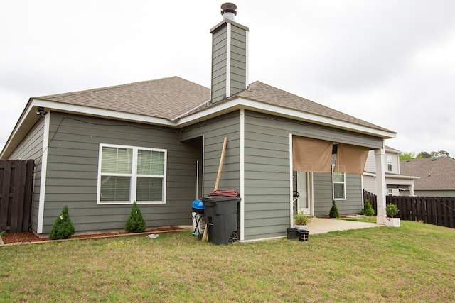 6845 Admiral Dr, Midland, GA 31820 - rear view of property with a shingled roof, a lawn, a chimney, fence, and a patio