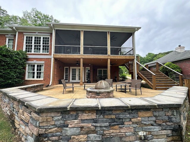 back of house with a ceiling fan, a patio, a sunroom, and an outdoor fire pit