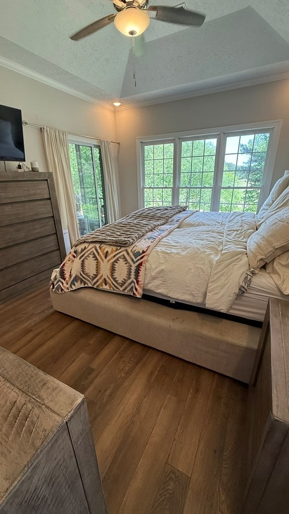 bedroom with crown molding, a textured ceiling, a ceiling fan, and wood finished floors