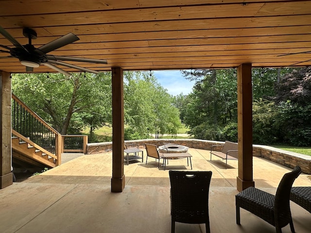 view of patio / terrace with ceiling fan, stairs, and an outdoor fire pit