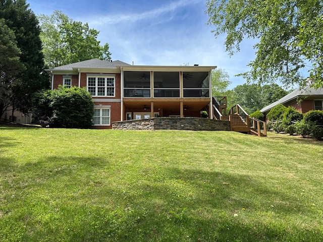 rear view of house featuring stairs, brick siding, ceiling fan, a sunroom, and a yard
