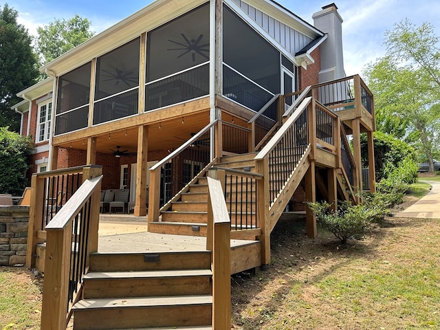 rear view of property with brick siding, a wooden deck, a sunroom, stairway, and a ceiling fan