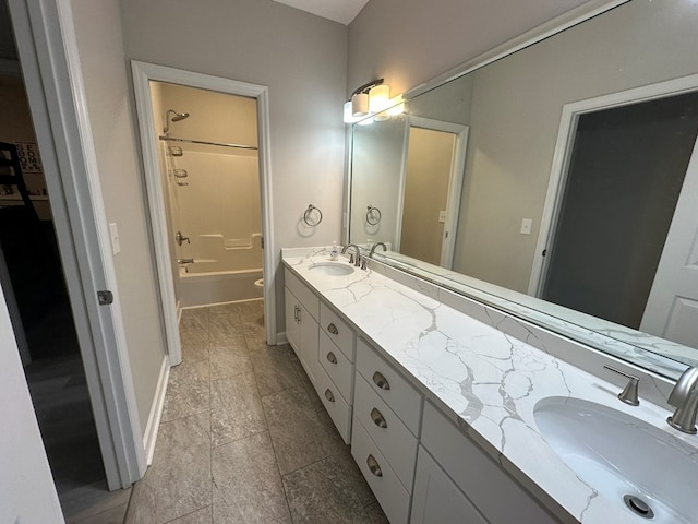 bathroom with a sink, baseboards, double vanity, and  shower combination