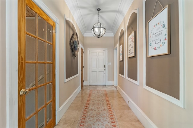 doorway featuring a notable chandelier and crown molding