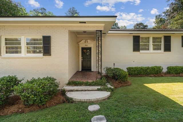 property entrance featuring a lawn