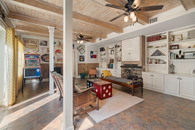 living room featuring beam ceiling, ceiling fan, wooden walls, and wood ceiling