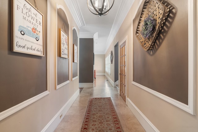 hall featuring ornamental molding, light tile patterned floors, and a chandelier