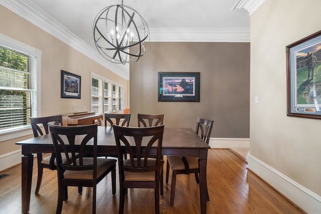 dining room with crown molding, hardwood / wood-style flooring, and an inviting chandelier