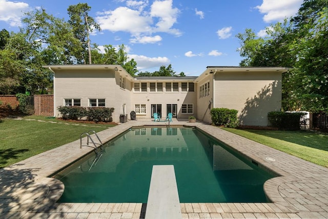 back of property with a fenced in pool, a yard, and a patio