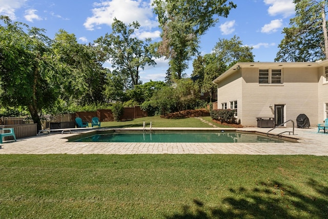 view of swimming pool featuring a yard and a patio area