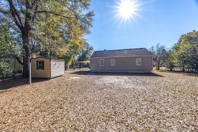 rear view of house with a storage shed