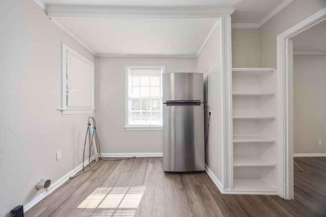 kitchen featuring stainless steel fridge, ornamental molding, and wood-type flooring