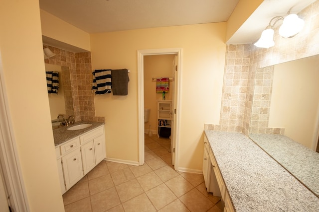 full bath featuring toilet, tile patterned flooring, baseboards, and vanity