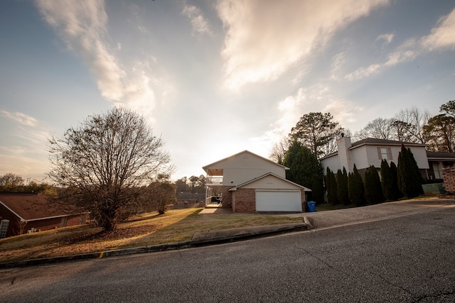 view of front of house with a garage, concrete driveway, and brick siding