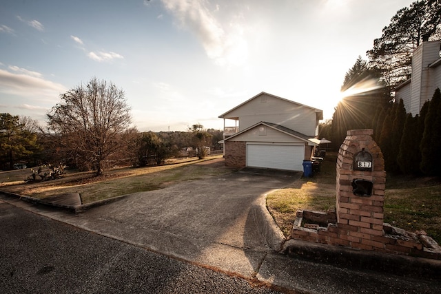 view of side of property with a garage, driveway, and brick siding