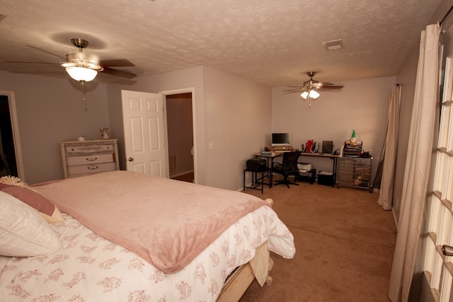 bedroom with a textured ceiling, carpet floors, visible vents, and a ceiling fan