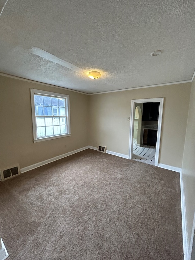 carpeted spare room featuring crown molding and a textured ceiling