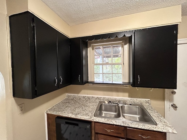 kitchen featuring dishwashing machine, sink, and a textured ceiling