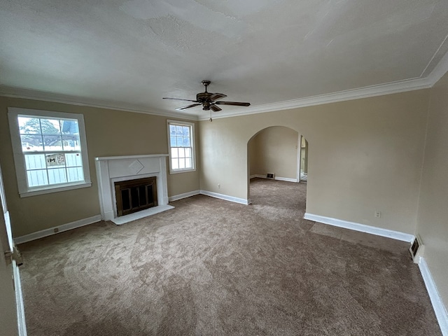 unfurnished living room with a high end fireplace, ceiling fan, carpet, and ornamental molding