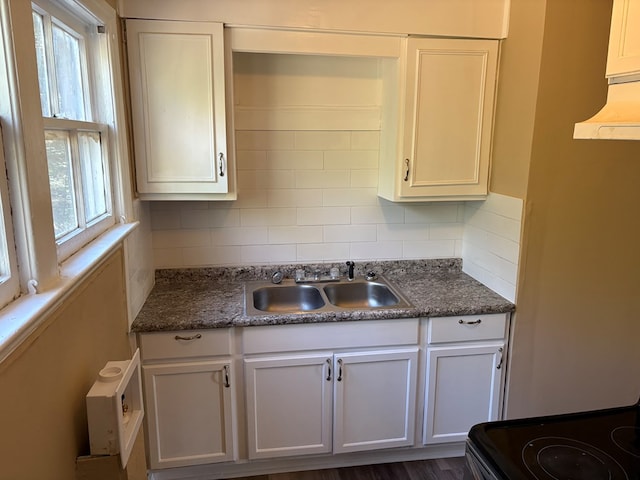 kitchen featuring backsplash, white cabinetry, and sink