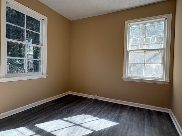 spare room featuring dark hardwood / wood-style floors and a textured ceiling