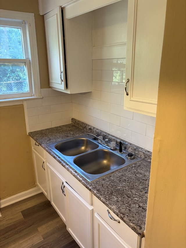 kitchen featuring dark hardwood / wood-style flooring, decorative backsplash, sink, and white cabinets