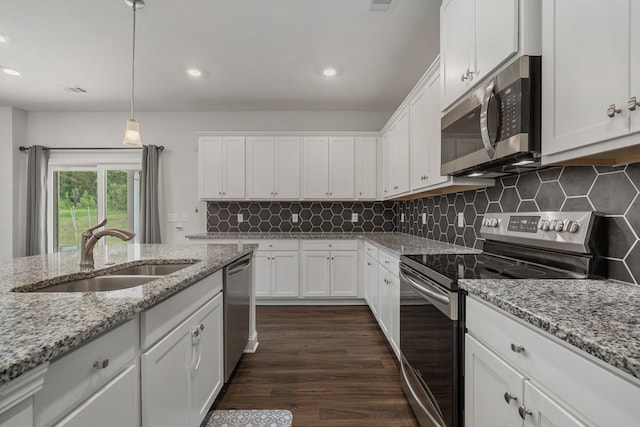 kitchen featuring sink, stainless steel appliances, dark hardwood / wood-style floors, decorative light fixtures, and white cabinets