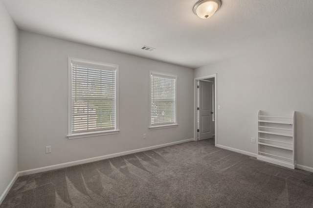 carpeted spare room featuring a healthy amount of sunlight