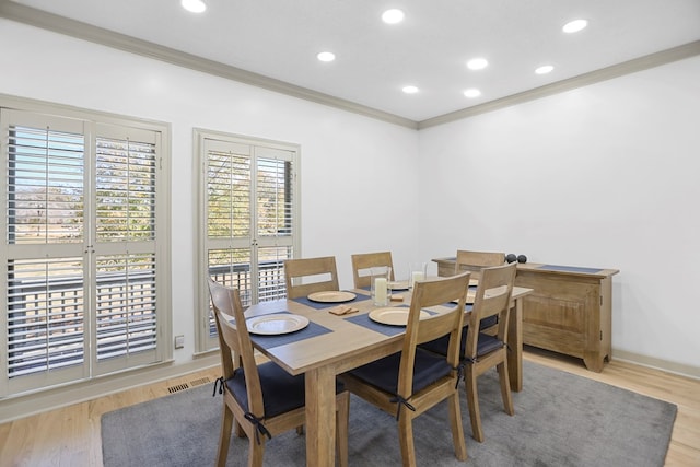 dining room with light hardwood / wood-style floors and ornamental molding