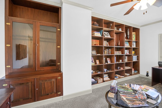 interior space featuring a textured ceiling, dark carpet, ceiling fan, and crown molding