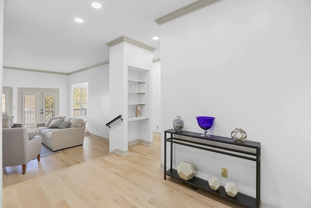 living room featuring french doors, light hardwood / wood-style flooring, and crown molding