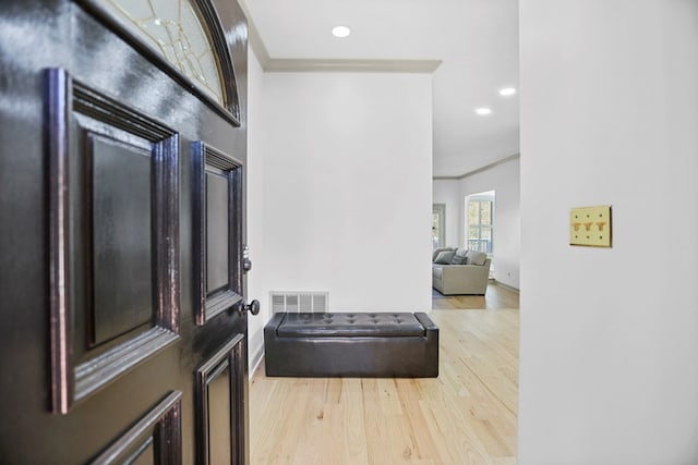 entrance foyer with ornamental molding and light wood-type flooring