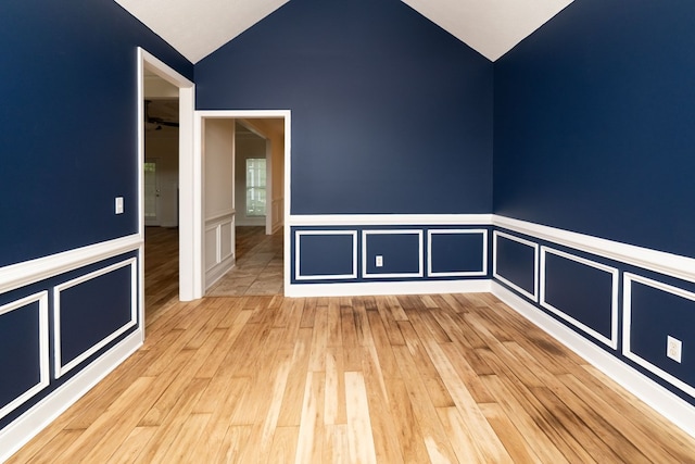 144 Lee Road 2083, Phenix City, AL 36870 - unfurnished room with lofted ceiling, light wood-style flooring, a wainscoted wall, and a decorative wall