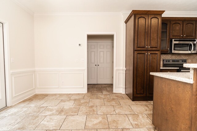 144 Lee Road 2083, Phenix City, AL 36870 - kitchen featuring stainless steel appliances, ornamental molding, light stone finish floors, tasteful backsplash, and dark brown cabinetry