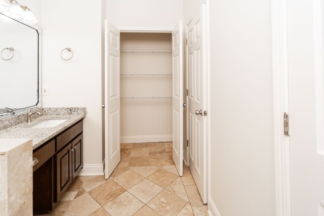 144 Lee Road 2083, Phenix City, AL 36870 - bathroom with vanity, baseboards, a walk in closet, and stone finish flooring