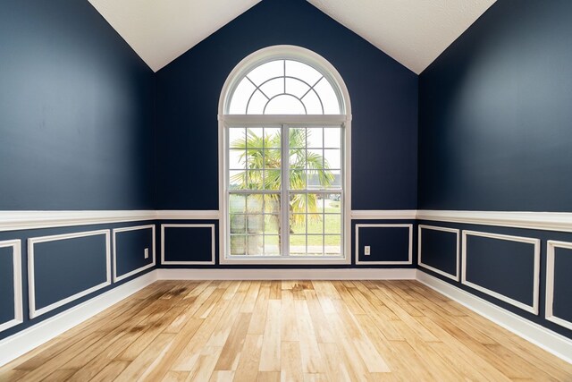 144 Lee Road 2083, Phenix City, AL 36870 - unfurnished room with vaulted ceiling, wood finished floors, and a wainscoted wall