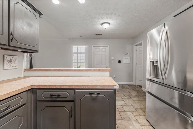 176 Lee Road 0504, Phenix City, AL 36870 - kitchen with stainless steel refrigerator with ice dispenser, a peninsula, gray cabinets, light countertops, and light stone finish floors