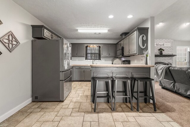 176 Lee Road 0504, Phenix City, AL 36870 - kitchen with freestanding refrigerator, gray cabinets, a peninsula, black microwave, and a breakfast bar area