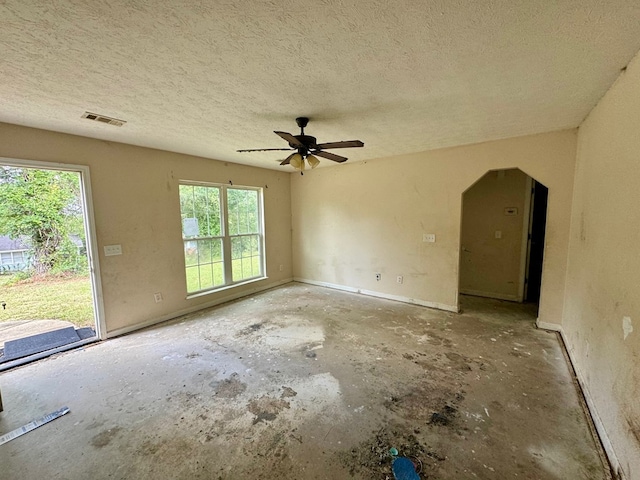 spare room featuring ceiling fan, a healthy amount of sunlight, and a textured ceiling